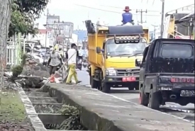 Petugas kebersihan tampak membuang sampah diselokan (sumber FB)