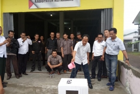 Ketua KPU Kepahiang Mirzan Pranoto Hidayat Rabu (19/12/18) menguji kekuatan kotak suara kardus dengan cara menduduki hingga menyiraminya dengan air